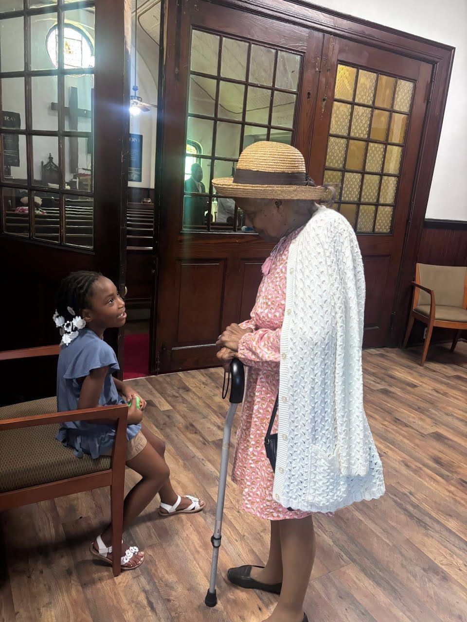 A young girl and an elder member of the congregation sharing a conversation