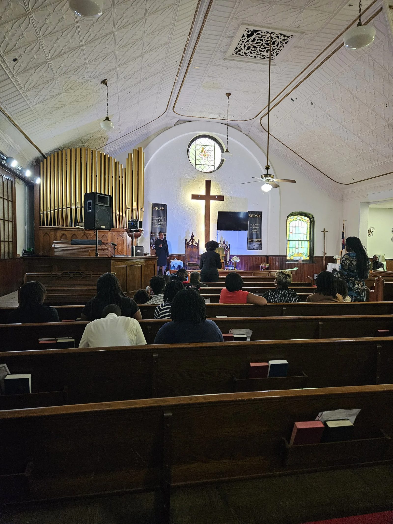 Sanctuary of Alleyne Memorial A.M.E. Zion Church with organ pipes and illuminated cross